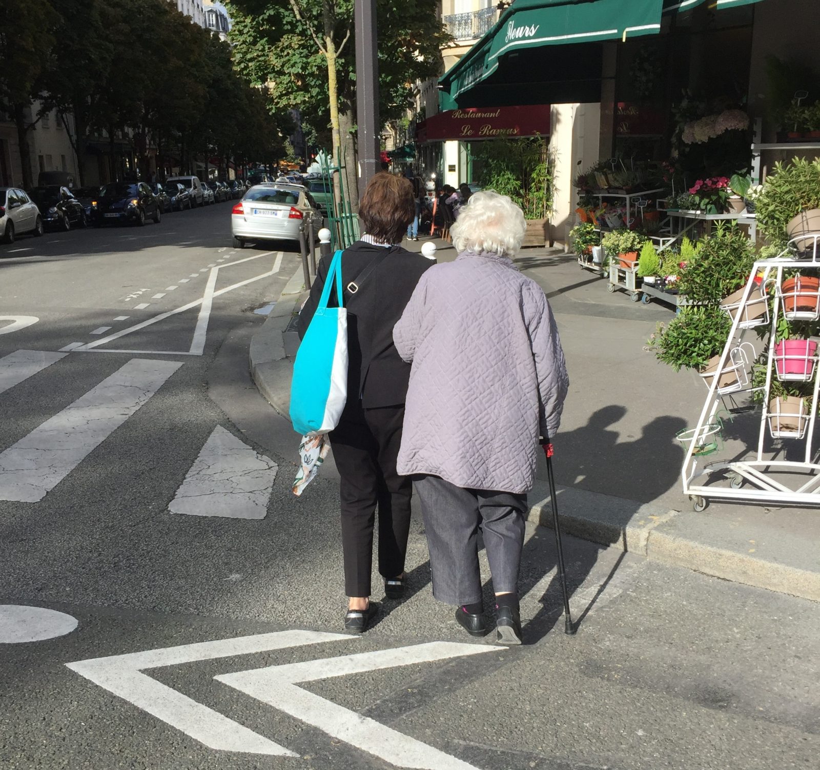 woman helping an elderly woman across the street