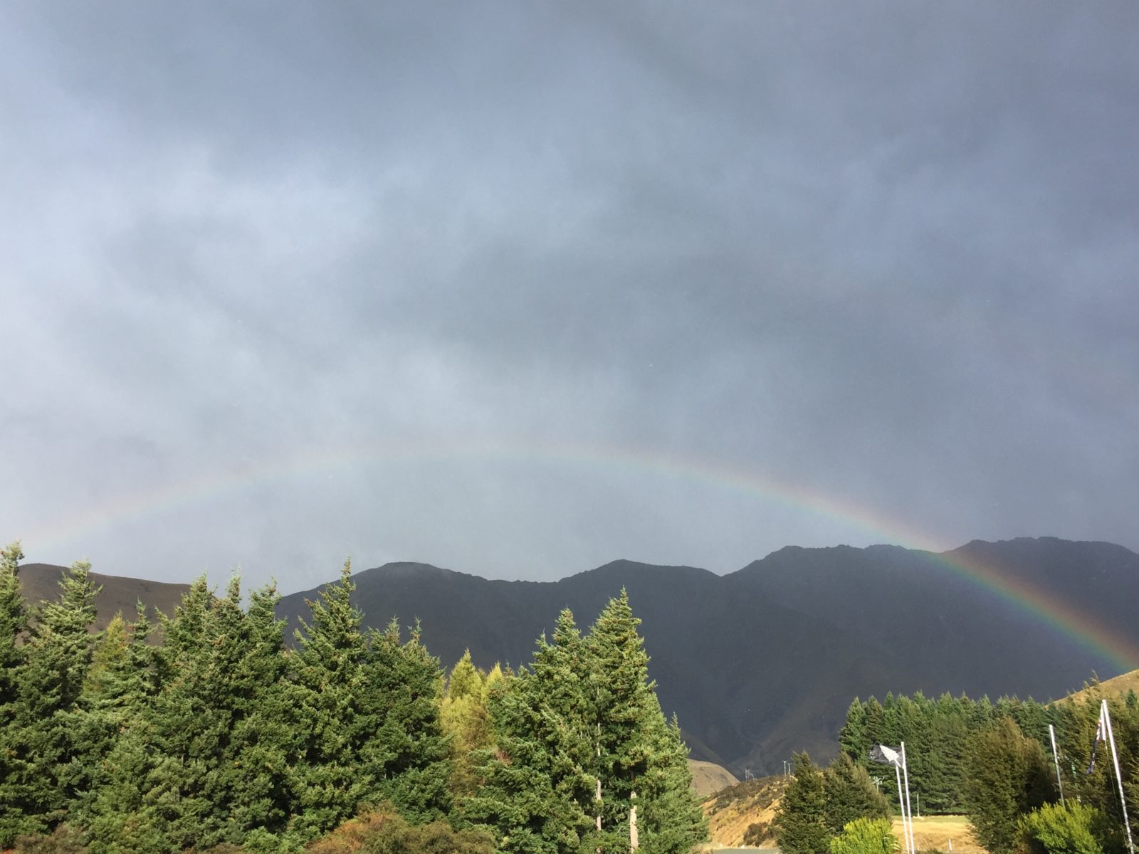 rainbow over the trees and mountains